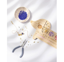 Kit de création de bijoux avec plateau en bois en forme de teckel, pince, perles variées et un collier.