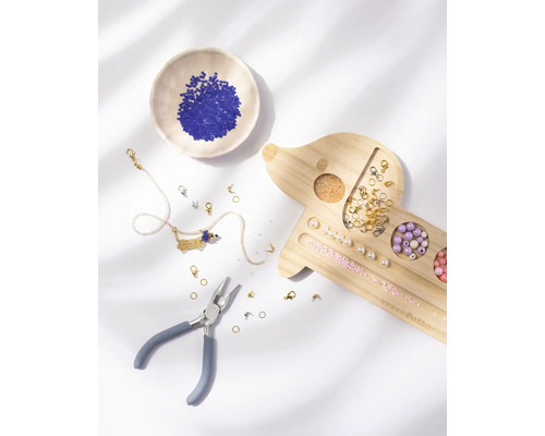 Kit de création de bijoux avec plateau en bois en forme de teckel, pince, perles variées et un collier.