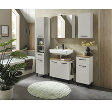 Ensemble de salle de bain blanc moderne avec détails aspect bois, lavabo, armoire de toilette et meubles à poignées noires.
