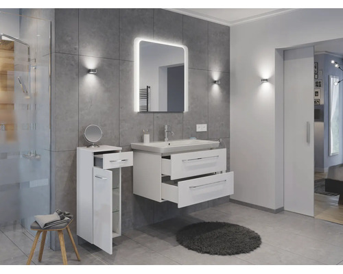Salle de bains moderne avec meuble sous vasque blanc, lavabo, miroir éclairé et armoire latérale devant des carreaux gris.