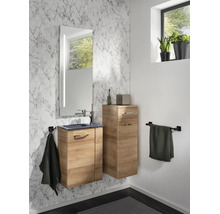 Modernes Badezimmer mit Waschtischunterschrank und Beischrank in Holzoptik vor einer Wand in Marmoroptik mit beleuchtetem Spiegel.