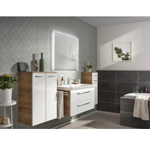Ensemble de meubles de salle de bains moderne et clair en blanc et aspect chêne avec miroir éclairé, lavabo et armoires.