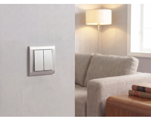 Interrupteur double moderne sur un mur dans un salon lumineux avec canapé, lampadaire et table en bois.