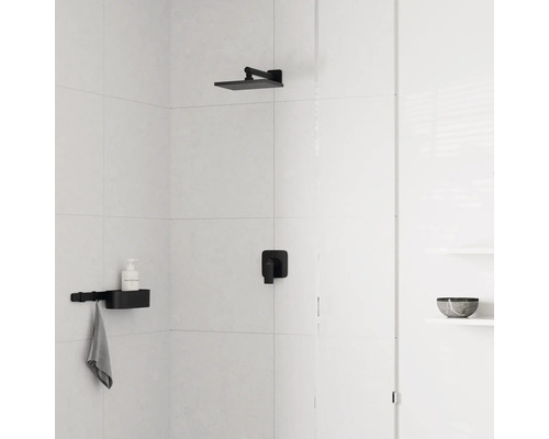 Douche lumineuse avec carrelage blanc, pomme de douche de tête noire, mitigeur encastré noir et étagère de douche noire avec porte-serviette.
