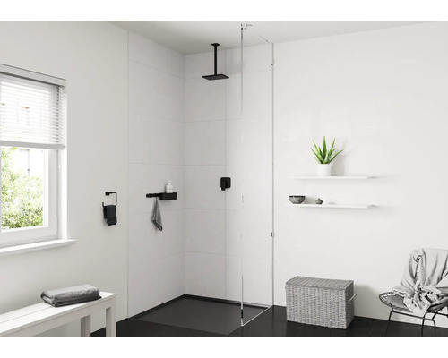 Salle de bains moderne et lumineuse avec douche à l'italienne, pommeau de douche noir au plafond, paroi en verre et accessoires noirs.