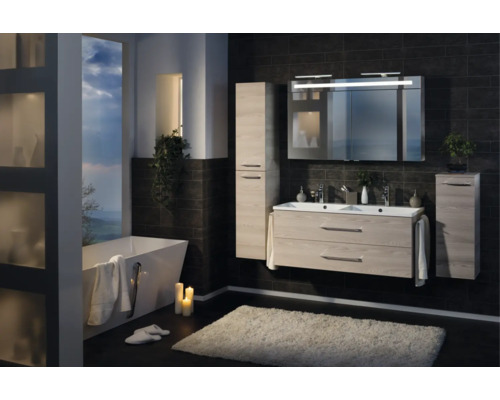 Modernes Badezimmerset in Holzoptik mit Doppelwaschtisch, Spiegelschrank, Hochschränken und freistehender Badewanne an dunkler Fliesenwand.