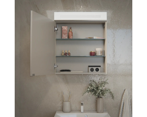 Armoire de toilette dans la salle de bains avec éclairage LED, deux étagères en verre, porte ouverte et divers produits de soin.