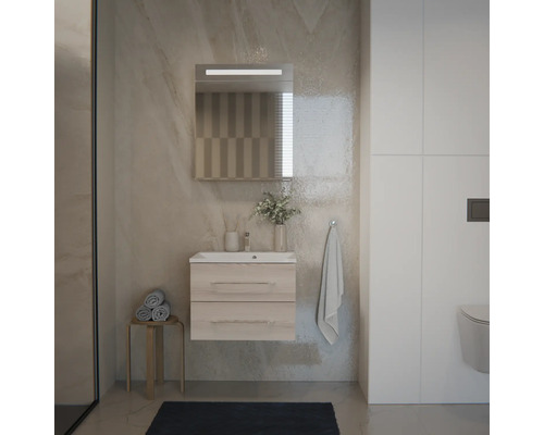 Ensemble de salle de bain moderne avec meuble sous-vasque suspendu aspect bois, lavabo blanc et miroir éclairé sur un mur aspect pierre.