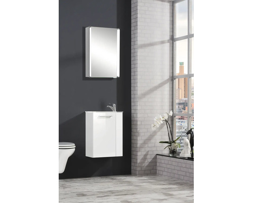 Meuble sous-vasque blanc et armoire de toilette avec éclairage en céramique et verre dans une salle de bains lumineuse et organisée.