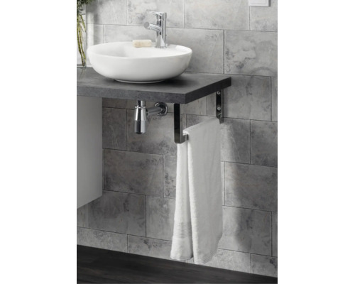 Plan de toilette avec vasque à poser, robinetterie et porte-serviettes intégré devant un mur en carrelage gris.