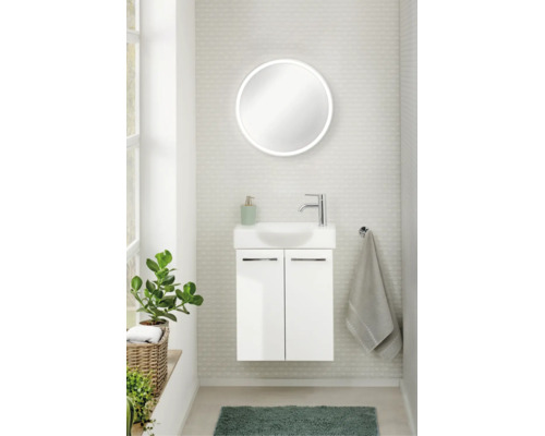 WC d'invités moderne avec meuble sous-vasque suspendu blanc, petite vasque, robinetterie chromée et miroir LED rond.