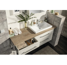 Meuble de salle de bains avec vasque blanche, plan de toilette en décor chêne et meuble sous-lavabo blanc à deux tiroirs.