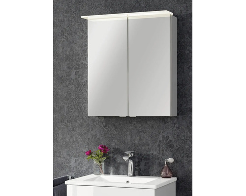 Armoire de toilette à deux portes avec éclairage LED au-dessus d'un lavabo blanc devant un mur à motifs.