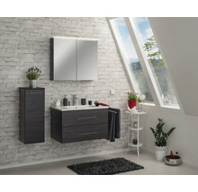 Modernes, helles Badezimmer mit anthrazitfarbenem Waschtischunterschrank, Keramikbecken, Spiegelschrank und Hochschrank vor einer Ziegelwand.
