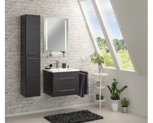 Ensemble de salle de bains moderne en bois avec meuble sous-lavabo, armoire haute et miroir éclairé sur un mur en briques.