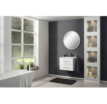 Salle de bains moderne et lumineuse avec meuble sous vasque blanc, miroir rond, baignoire îlot et armoire haute éclairée.