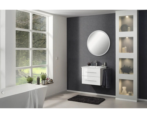 Salle de bains moderne et lumineuse avec meuble sous vasque blanc, miroir rond, baignoire îlot et armoire haute éclairée.