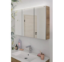 Armoire de toilette à trois portes avec éclairage LED et corps en aspect bois au-dessus d'un lavabo dans la salle de bain.