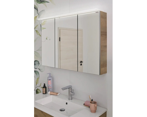Armoire de toilette à trois portes avec éclairage LED et corps en aspect bois au-dessus d'un lavabo dans la salle de bain.