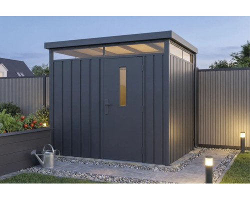 Modernes Gerätehaus aus Metall in Anthrazit mit Flachdach und Lichtband in einem beleuchteten Garten.