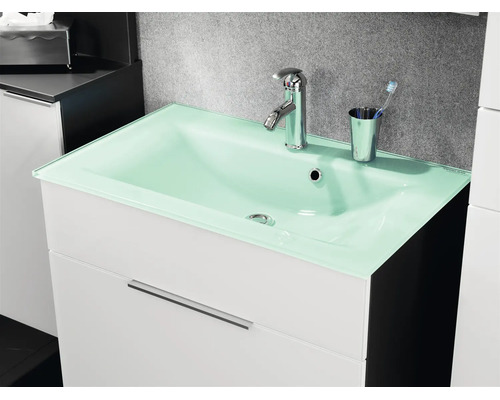 Badezimmer-Unterschrank mit hellgrünem Glaswaschbecken, verchromter Armatur und Zahnbürstenhalter.