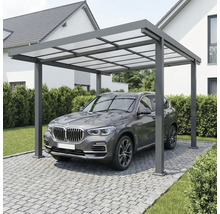 Moderner Carport aus Aluminium mit lichtdurchlässigem Dach über einem Fahrzeug auf einer gepflasterten Einfahrt neben einem Wohnhaus.