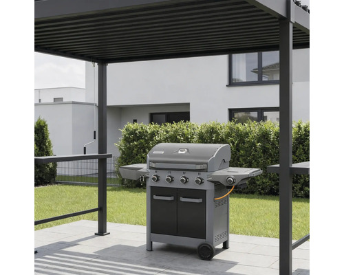 Gasgrill mit vier Brennern und Seitenablagen auf einer gepflasterten Terrasse unter einer modernen Pergola aus Metall im Garten.