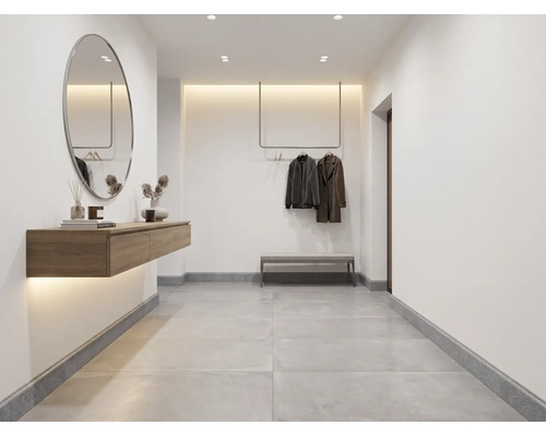Entrée minimaliste avec carreaux de sol gris, miroir mural ovale, console en bois suspendue et tringle à vêtements fixée au plafond.