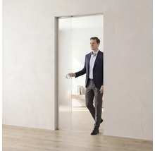 Glasschiebetür in einem hellen, minimalistischen Raum mit einer Person, die den runden Türgriff betätigt.