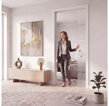 Porte coulissante moderne en verre avec bandes horizontales dans un salon lumineux avec une femme passant la porte.