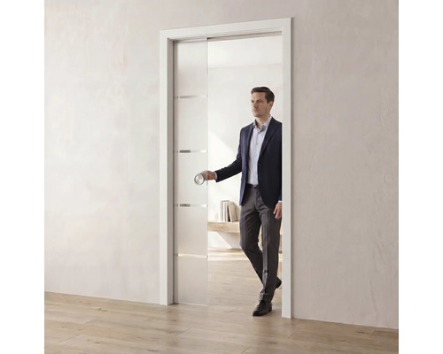 Moderne Glasschiebetür in der Wand laufend, satiniertes Glas mit Querstreifen und rundem Griff in einem hellen, großzügigen Raum.