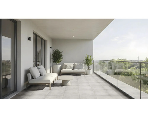 Moderner, großzügiger Balkon mit Loungemöbeln, Couchtisch, gefliestem Boden und Glasgeländer mit Blick in die Natur.