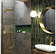 Modernes Badezimmer mit grauen Schieferoptik-Fliesen, goldenen Duscharmaturen, grünen Mosaikfliesen, rundem Spiegel und Aufsatzwaschbecken.