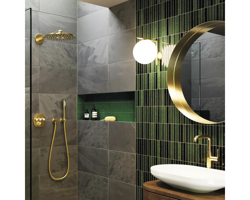 Modernes Badezimmer mit grauen Schieferoptik-Fliesen, goldenen Duscharmaturen, grünen Mosaikfliesen, rundem Spiegel und Aufsatzwaschbecken.