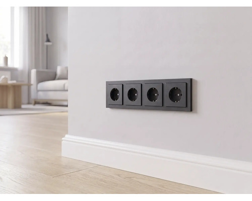 Eine 4-fach Steckdose in Schwarz an einer hellen Wand über einer weißen Fußleiste in einem modern eingerichteten Wohnzimmer.