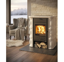 Poêle à bois avec carreaux de céramique et feu brûlant dans un salon lumineux avec fauteuil, couverture et tapis.