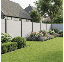 Clôture de jardin moderne avec panneaux aspect béton et poteaux métalliques foncés dans un jardin avec parterres de fleurs et pelouse.