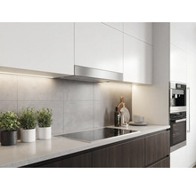 Cuisine moderne avec éléments hauts blancs, hotte aspirante en acier inoxydable, paroi arrière grise et plaque de cuisson.