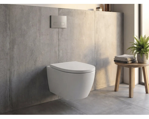 Wand-WC an engem modernen Buedzëmmer mat Betonoptik, Betätegungsklapp un der Mauer an engem Holzhocker mat Handdicher an enger Planz.