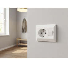 Combinaison prise de courant avec terre et interrupteur sur un mur clair dans une pièce moderne et lumineuse avec parquet.