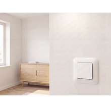 Interrupteur moderne sur un mur dans une pièce lumineuse et minimaliste avec un buffet en bois et une fenêtre.