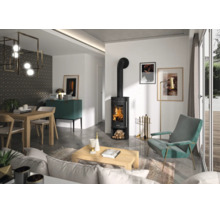 Salon moderne avec un poêle à bois noir avec feu apparent, une table en bois, un fauteuil turquoise et de grandes baies vitrées.
