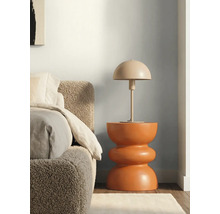 Chambre à coucher avec tête de lit texturée, table de chevet sculpturale et lampe de table en forme de dôme devant un mur bicolore.