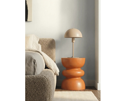 Chambre à coucher avec tête de lit texturée, table de chevet sculpturale et lampe de table en forme de dôme devant un mur bicolore.