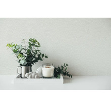 Papier peint intissé structuré dans une pièce avec un plateau décoratif, des branches de eucalyptus et une bougie.