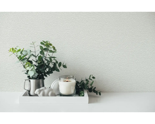 Papier peint intissé structuré dans une pièce avec un plateau décoratif, des branches de eucalyptus et une bougie.