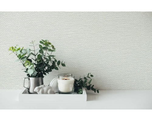 Papier peint structuré à motif horizontal derrière un plateau décoratif avec des branches d'eucalyptus et une bougie allumée.