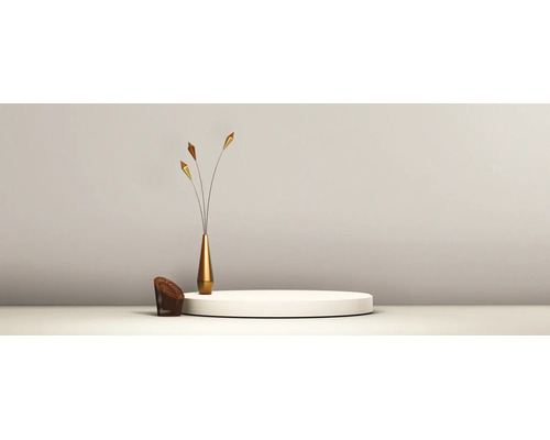 Décor minimaliste avec un podium blanc circulaire, un vase doré élancé doté de tiges décoratives et un petit élément tressé.