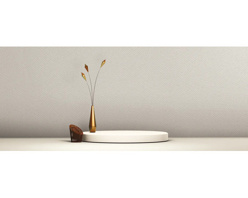 Papier peint clair et structuré dans une pièce minimaliste avec un podium rond blanc et un vase doré étroit.