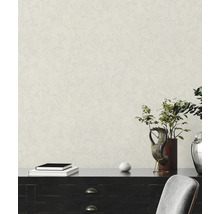Papier peint texturé effet crépi dans une pièce lumineuse avec buffet sombre, plantes et objets de décoration.